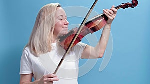 4K. Young caucasian blonde woman playing violin. girl playing the violin