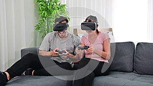 4K Young happy couple playing video games wearing virtual reality glasses