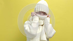 4k. Young smiling woman wearing white knitted sweater, scarf and hat