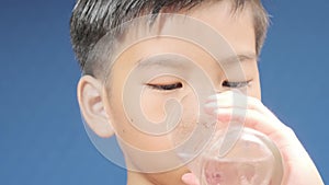 4k Zoom out of young Asian boy drinking water