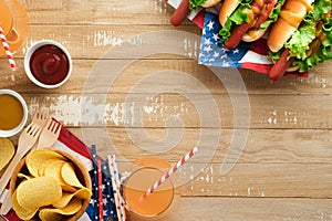 4th of July American Independence Day traditional picnic food. Hot dog with potato chips and cocktail, American flags and symbols