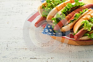 4th of July American Independence Day traditional picnic food. Hot dog with potato chips and cocktail, American flags and symbols