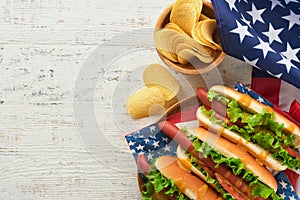 4th of July American Independence Day traditional picnic food. Hot dog with potato chips and cocktail, American flags and symbols