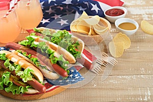 4th of July American Independence Day traditional picnic food. Hot dog with potato chips and cocktail, American flags and symbols
