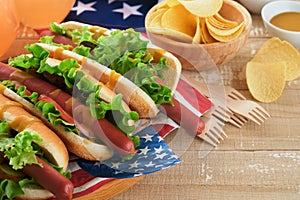 4th of July American Independence Day traditional picnic food. Hot dog with potato chips and cocktail, American flags and symbols