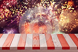 4th of July background. Wooden table over fireworks and sparkles. Independence day celebration