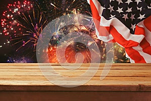 4th of July background. Wooden table over fireworks and USA flag. Independence day celebration