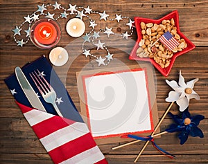 4th of July Table Setting with Flag Napkin, silverware, decorations and a blank white card with space for copy, text or your words