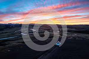 4wd car parked on dirt road among moss lava field in the sunset on Icelandic highlands in summer of Iceland
