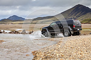 4WD car wades river in Iceland