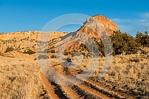 4wd dirt road curves toward a high desert mountain peak at Ghost Ranch