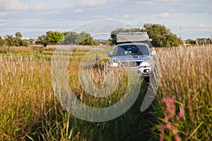 4x4 car in a meadow with high grass