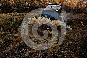 4x4 concept. SUV or offroader on mud road. Large rocks on the road extreme travel adventure in nature. Track on mud