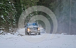 4x4 truck on winter snow road in forest