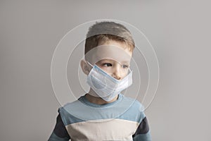 5-7 years old child wearing surgical mask. Little boy trying to stay healthy by wearing a mask to protect