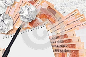 5 Belorussian rubles bills and balls of crumpled paper with blank notepad. Bad ideas or less of inspiration concept. Searching