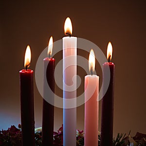 5 candles burning on tradition christian advent wreath, black background