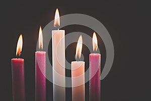 5 candles burning on tradition christian advent wreath, black background