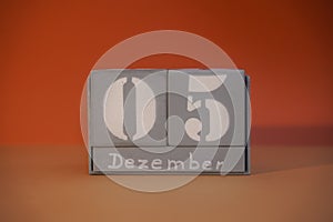 5 Dezember on wooden grey cubes. Calendar cube date 05 December. Concept of date. Copy space for text. Educational cube