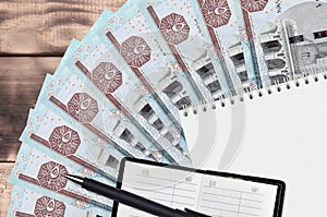 5 Egyptian pounds bills fan and notepad with contact book and black pen. Concept of financial planning and business strategy