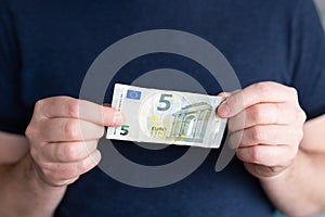 5 euro banknote. Man Hand holding cash paper money.Financial and money concept. job seeker. unemployed.