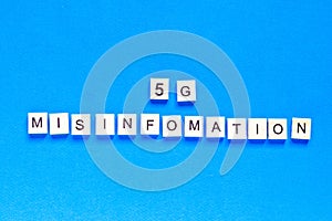 5 g mystification. 5 G. Five G`s, written in wooden letters on a blue background. top view. Flat layout. Wireless