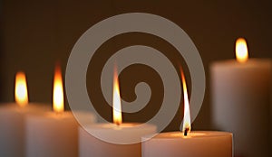 5 glowing burning white wax candles with long flames