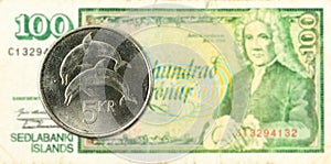 5 icelandic krona coin against 100 icelandic krona bank note