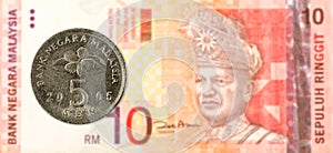 5 malaysian sen coin against 10 malaysian ringgit bank note