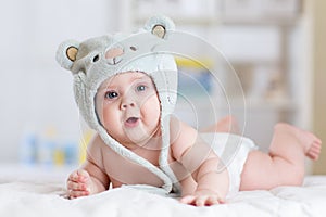 5 months baby girl weared in funny hat lying down on a blanket