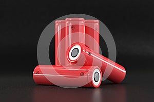 5 red cylindrical batteries on a black background. Storage battery or secondary cell. Rechargeable batteries for