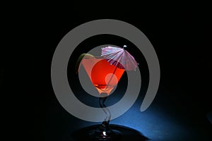 About a 5 second time laps aka Bulb exposure of orange liquid in a martini glass lit up with a photo