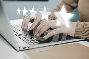 5 star rating. business woman hand working on laptop with five star button on visual screen to review good rating, digital marketi