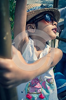 5 year old British Indian girl plays on a luggage rack at a hotel.