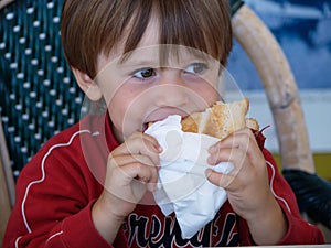 5-year-old child eats a sandwich