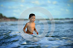 5 years old cute and happy child feeling crazy free having fun on the beach playing on water and sea waves enjoying holidays