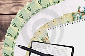 50 Belorussian rubles bills fan and notepad with contact book and black pen. Concept of financial planning and business strategy