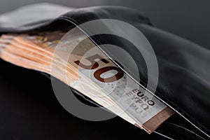 50 euro banknotes in a black wallet close-up. Cash in a wallet