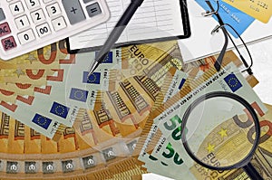 50 euro bills and calculator with glasses and pen. Tax payment season concept or investment solutions. Searching a job with high