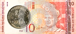 50 malaysian sen coin against 10 malaysian ringgit bank note