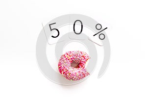 50% off discount - sale concept with bitten donut - on white background top-down copy space