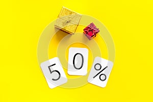 50% off discount - sale concept with present box - on yellow background top-down copy space