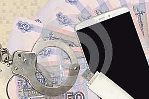 50 russian rubles bills and smartphone with police handcuffs. Concept of hackers phishing attacks, illegal scam or malware soft