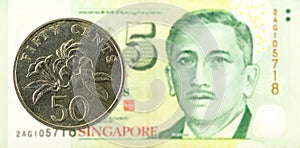 50 singapore cent coin against 5 singapore dollar banknote