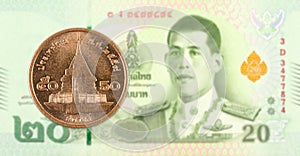 50 thai satang coin against 20 new thai baht banknote