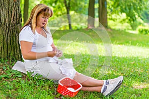 50-year-old woman knitting in the park