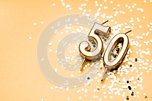 50 years celebration festive background made with golden candles in the form of number Fifty lying on sparkles