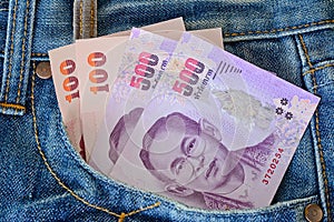 500 and 100 banknotes in men' s blue jeans pocket