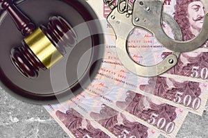 500 Hungarian forint bills and judge hammer with police handcuffs on court desk. Concept of judicial trial or bribery. Tax