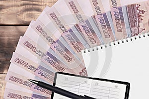 500 russian rubles bills fan and notepad with contact book and black pen. Concept of financial planning and business strategy